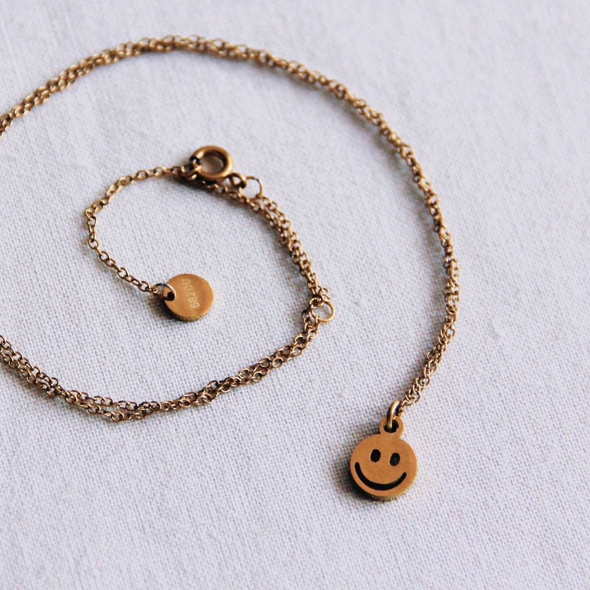 Edelstalen fijne ketting met smiley - goud
