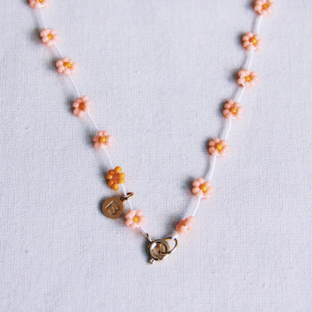 BAZOU RVS ketting met madeliefjesbloem – zalmroze/oranje