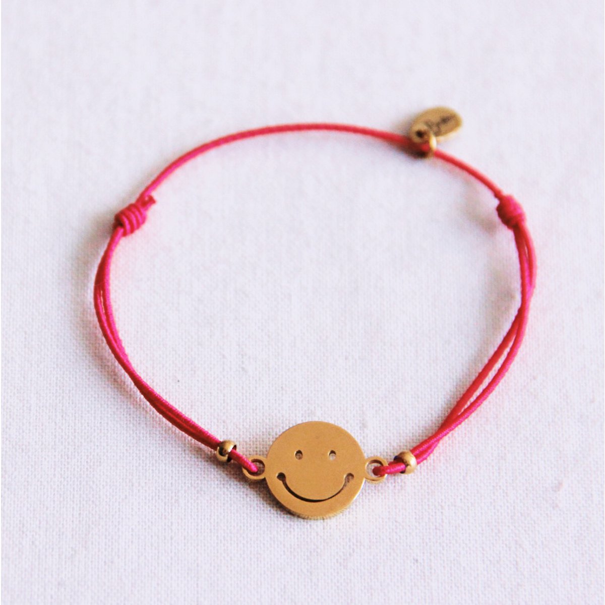 Elastische armband met smiley - fuchsia
