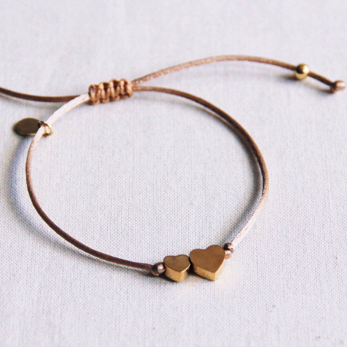 FW138 - Satijnen armband met klein en groot hart - taupe / goud